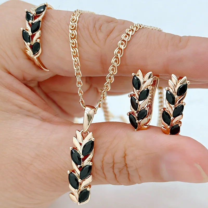 Rose gold jewelry set with black marquise-cut crystals featuring a leaf-inspired pendant necklace, matching earrings, and ring.